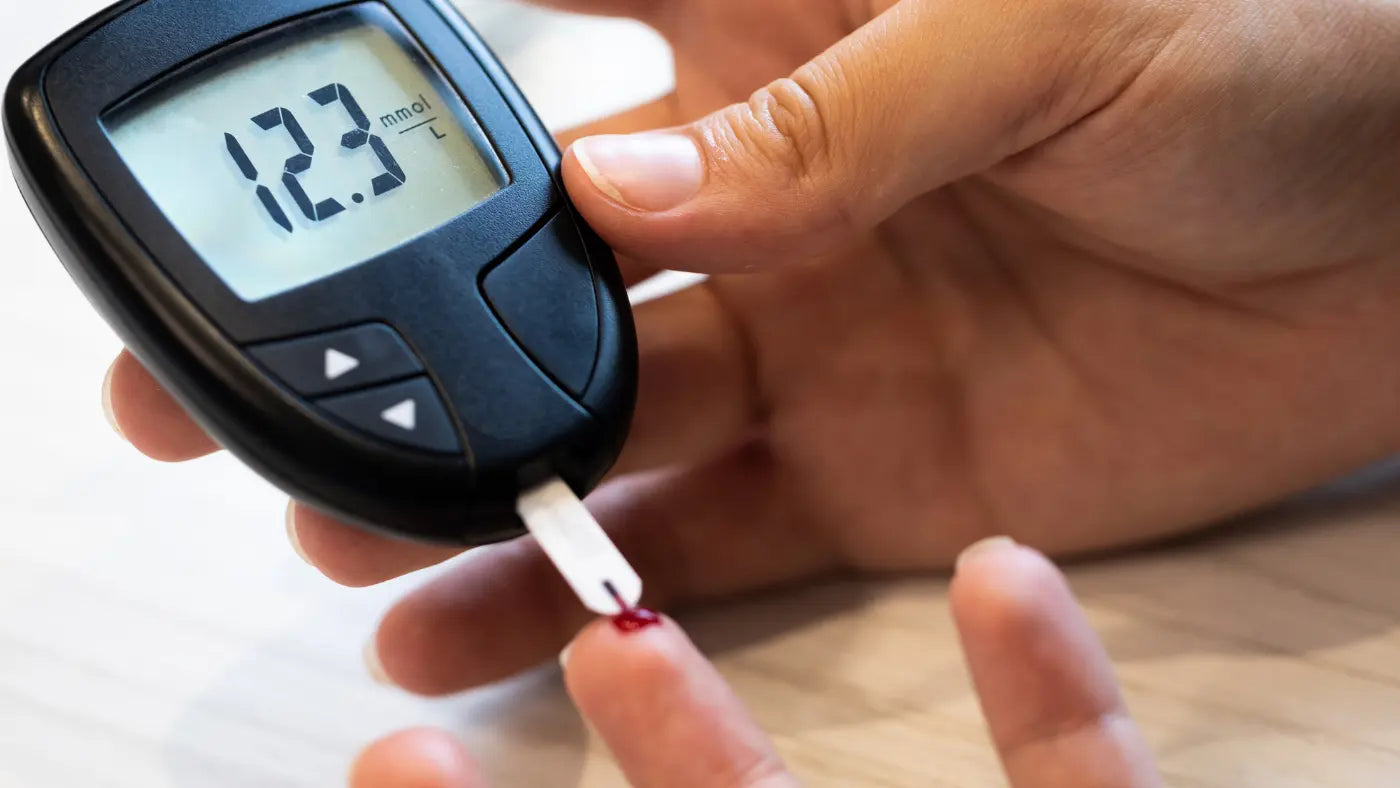 Een persoon met een bloedglucosemeter die een hoge suikerspiegel laat zien.