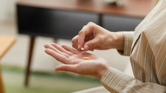 Persoon neemt twee supplementen in, symbool voor het combineren van resveratrol en NAD voor optimale ondersteuning van celgezondheid